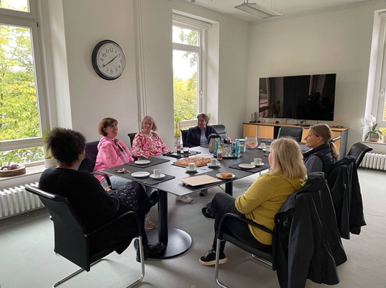 Sechs Personen sitzen in einem Konferenzraum am Tisch und unterhalten sich. Sie sind Teilnehmer des Aktionstags "S(ch)ichtwechsel" in der Pestalozzi-Stiftung.